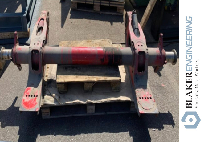 Metal fabrication: Heavy-duty metal axle assembly on a wooden pallet. Blaker Engineering.